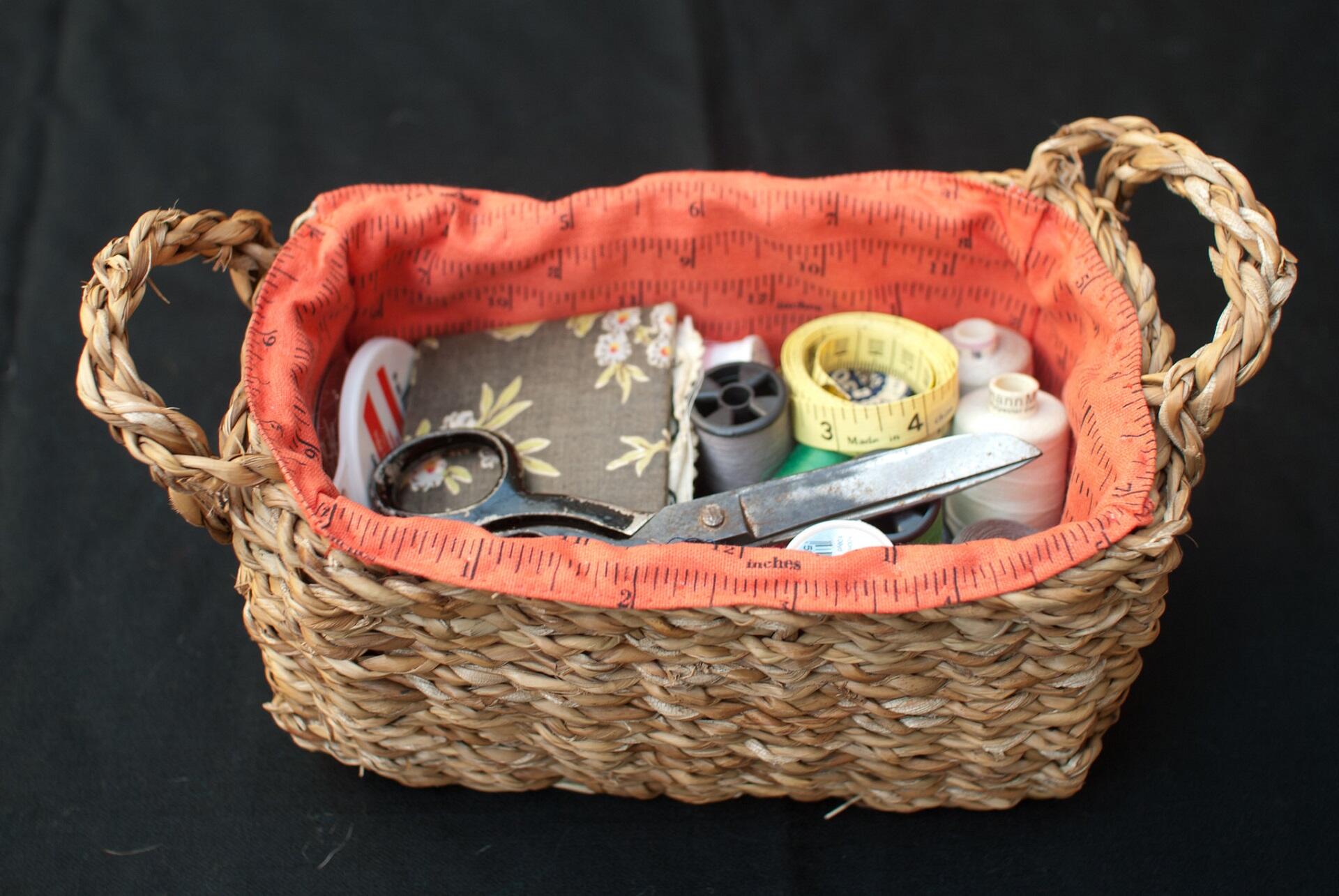 A basket with sewing supplies in it.