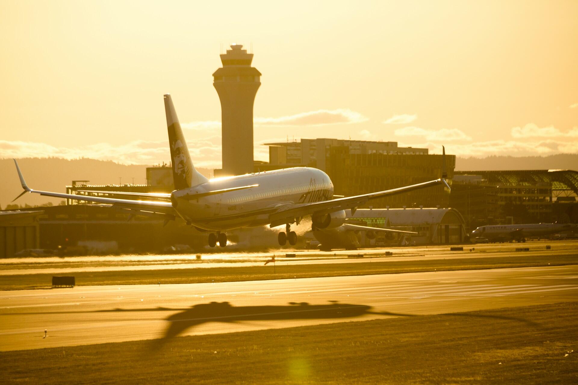 An airplane landing in the golden early morning light. 